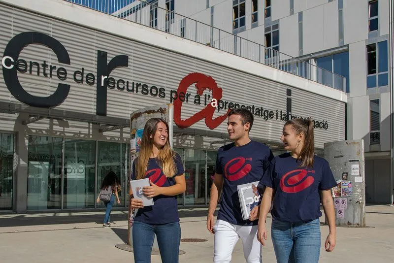 Estudiantes con la camiseta de Fem Esports URV frente al Centre de Recursos del campus