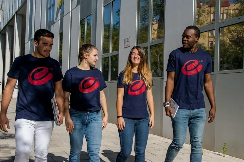 Estudiantes con la camiseta de Fem Esports URV caminando por el campus