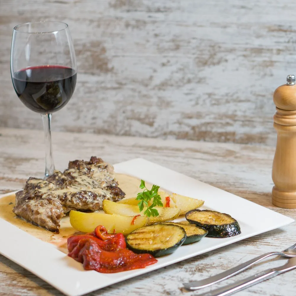 Carne a la brasa con verduras y vino tinto