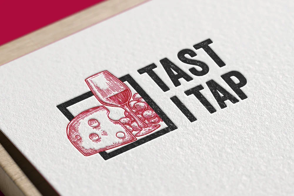 Logotipo de Tast i Tap con la ilustración de copa, queso y uvas